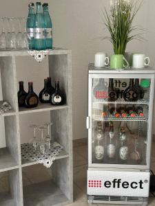 Holzkirchen的住宿－Gästehaus Krone，客房内的小冰箱,带瓶子和玻璃杯