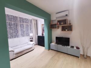 sala de estar con sofá blanco y TV en Colour House en Roma