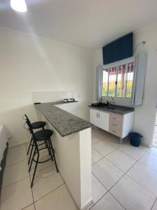 a kitchen with a counter and a chair in it at Pousada Helena e Heloá in Serra Negra