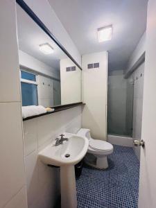 a bathroom with a sink and a toilet and a mirror at Duplex en primer piso - A media Cuadra Embajada USA in Lima