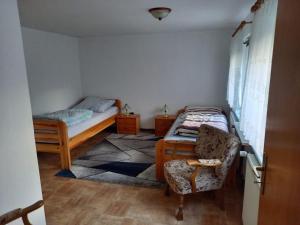 Cette petite chambre comprend deux lits et une chaise. dans l'établissement Ferienhaus Dobbenland, à Krummhörn