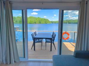 a table and chairs on a deck with a view of a lake at Parc de l'Île Melville 2 - Maison flottante in Shawinigan