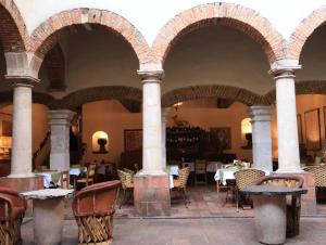 a restaurant with arches and tables and chairs at Hotel los Arcos in Taxco de Alarcón