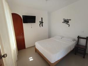 1 dormitorio con 1 cama y TV de pantalla plana en HOSPEDAJE LINDA LIRIO en Paracas