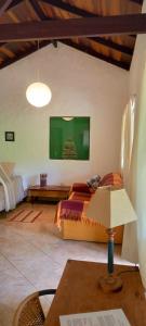 ein Schlafzimmer mit einem Bett und einem Tisch mit einer Lampe in der Unterkunft Casa Satori - Recanto de Paz in Alto Paraíso de Goiás