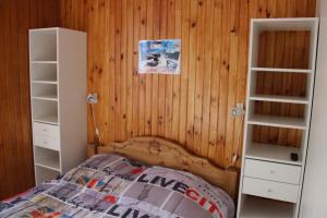 sypialnia z łóżkiem i drewnianymi ścianami w obiekcie Les cascades w mieście Mont-Dore