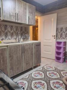 a kitchen with a sink and cabinets and a door at وحده فندقيه الخمائل علي المحور واركان بلازا زايد in Cairo