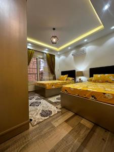 a bedroom with two beds and a window at وحده فندقيه الخمائل علي المحور واركان بلازا زايد in Cairo