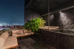 - un salon avec un canapé et une baignoire dans l'établissement Hotel Zelva Negra, à Medellín