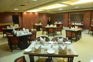 a man standing in a restaurant with tables and chairs at Hotel Seven Hills in Trivandrum