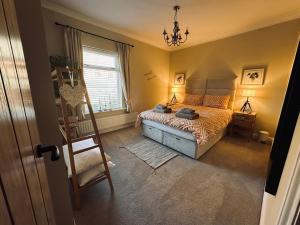1 dormitorio con 1 cama, 1 silla y 1 ventana en Overleigh Cottage, with optional Hot Tub hire en Chester
