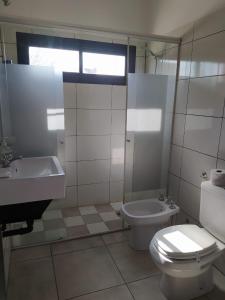 Baño blanco con aseo y lavamanos en Lantonia en Oncativo