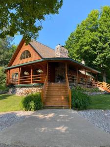 Cette grande maison en bois dispose d'une terrasse couverte et d'escaliers. dans l'établissement Rustic U.P. Retreat in Marquette, à Marquette
