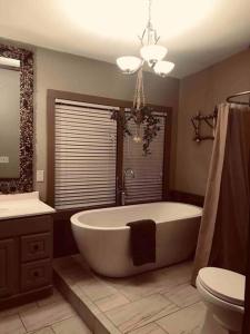 ein Badezimmer mit einer großen Badewanne und einem WC in der Unterkunft Rustic U.P. Retreat in Marquette in Marquette