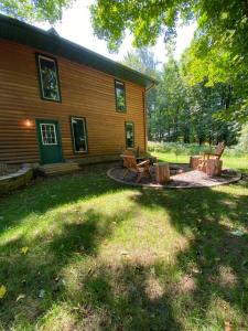 ein Haus mit einem Picknicktisch und einer Feuerstelle im Hof in der Unterkunft Rustic U.P. Retreat in Marquette in Marquette