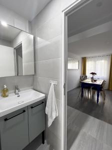 a white bathroom with a sink and a table at Le petit chic in Vaucresson