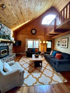 - un salon avec des canapés et une cheminée en pierre dans l'établissement Rustic U.P. Retreat in Marquette, à Marquette