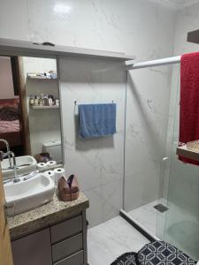 a bathroom with a glass shower and a sink at Casa 3 quartos portinho Cabo Frio in Cabo Frio