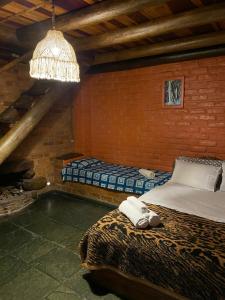 2 Betten in einem Zimmer mit Kronleuchter in der Unterkunft Pousada Chalés Vale do Sol in Conceição da Ibitipoca