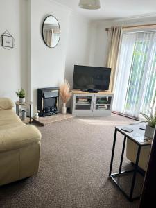 a living room with a flat screen tv and a couch at Chester Cottage in Frodingham