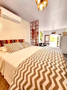 a bedroom with a large bed in a room at Bella Vista Kitnets in Farol de Santa Marta
