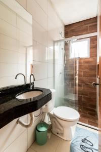 een badkamer met een toilet, een wastafel en een douche bij Casa nova condomínio fechado Praia Grande SP in Solemar