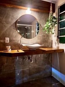 bagno con lavandino e specchio di Bella Vista Kitnets a Farol de Santa Marta
