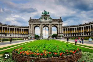 ein großes Gebäude mit einem großen Bogen mit Blumen davor in der Unterkunft beau studio (parlement européen) in Brüssel