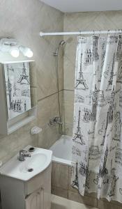 Baño con cortina de ducha con la torre Eiffel en Complejo Hunter Plottier - Neuquén en Plottier