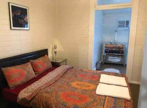 ein Schlafzimmer mit einem Bett und ein Fenster mit einem Klavier in der Unterkunft Free Wi-fi, spacious, Netflix. Long term discount in Bundaberg