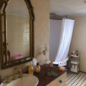 ein Bad mit einem Waschbecken und einem Spiegel in der Unterkunft Free Wi-fi, spacious, Netflix. Long term discount in Bundaberg