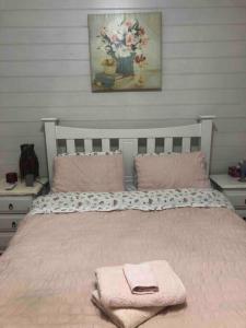 ein Schlafzimmer mit einem Bett mit rosa Handtüchern darauf in der Unterkunft Free Wi-fi, spacious, Netflix. Long term discount in Bundaberg