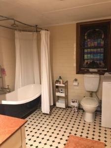 ein Bad mit einer Badewanne und einem WC in der Unterkunft Free Wi-fi, spacious, Netflix. Long term discount in Bundaberg