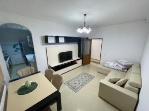 a living room with a couch and a table and a tv at Cozy Central Apartment in Sighetu Marmaţiei