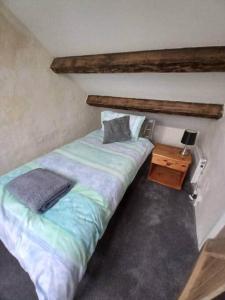 a small bedroom with a bed and a night stand at 3 Tan Y Coed in Brynkir