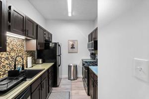 a kitchen with black cabinets and black appliances at Northside Pittsburgh Luxurious Apartment in Pittsburgh