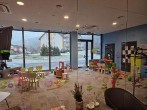 Habitación con zona de juegos infantil con sillas y juguetes. en Aparthotel Czarna Góra 239 en Sienna