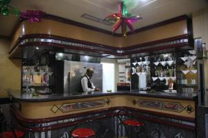 un hombre parado detrás de un bar en un restaurante en Hotel Amine, en Sfax