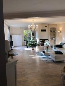 ein großes Wohnzimmer mit einem Kronleuchter und einem Wohnzimmer in der Unterkunft Charmante maison à 30 minutes de # Paris in Conflans-Sainte-Honorine