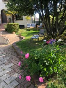 einen Garten mit einer Bank und rosa Blumen in der Unterkunft Charmante maison à 30 minutes de # Paris in Conflans-Sainte-Honorine