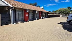 a car parked in a parking lot next to a building at Chrisserus Guest Rooms in Bloemfontein