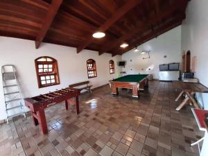 a room with a pool table and ping pong tables at Linda Chácara em Piracaia SP in Piracaia