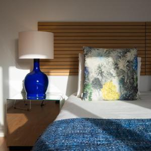 een blauwe lamp op een tafel naast een bed bij Ponta Delgada Flats - HOST & CHILL in Ponta Delgada