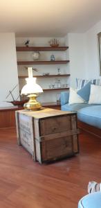 a living room with a table with a lamp on a box at Acquamarina in Rapallo