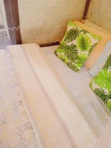 Una cama con dos almohadas encima. en BH Beachfront Homestay en El Nido