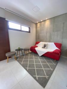a living room with a red couch and a table at Apt completo Caruaru, 2 quartos in Caruaru