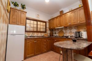 a kitchen with wooden cabinets and a white refrigerator at Teror Centro 2 in Teror