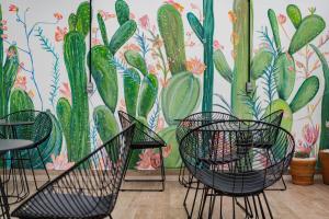 una habitación con sillas y un mural de cactus en Lofts & apartments Near Polanco by VH, en Ciudad de México