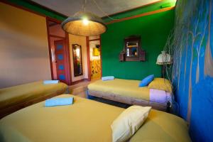 a room with three beds and a green wall at Soul - moradia criativa in Vila Franca de Xira