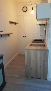 a kitchen with a sink and a clock on the wall at Studio le Grimaldi Menton in Menton